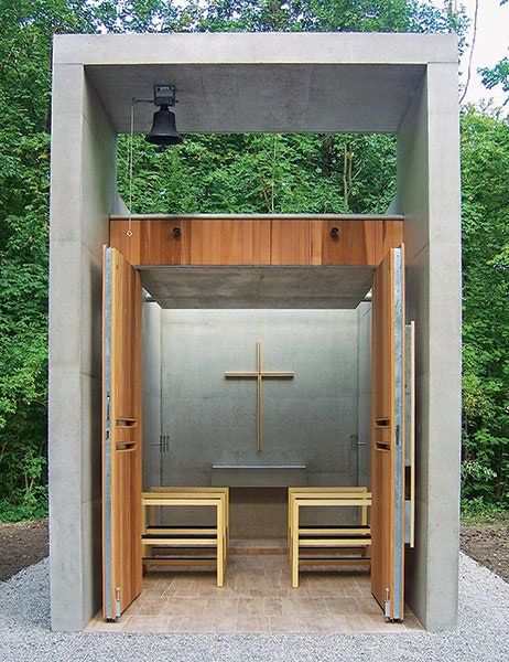 a small shrine with benches and a cross on the door