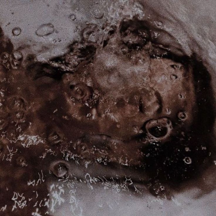 a black and white photo of a child's head in the water with bubbles