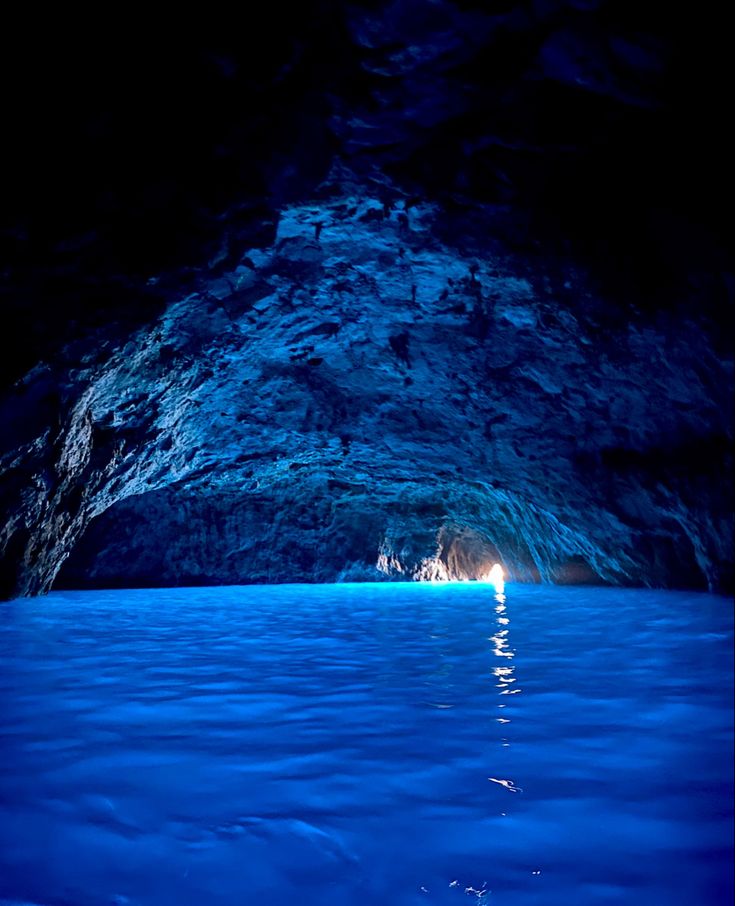 the inside of a cave with blue water