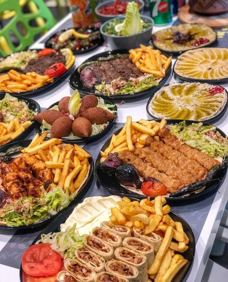 a table topped with lots of plates filled with food