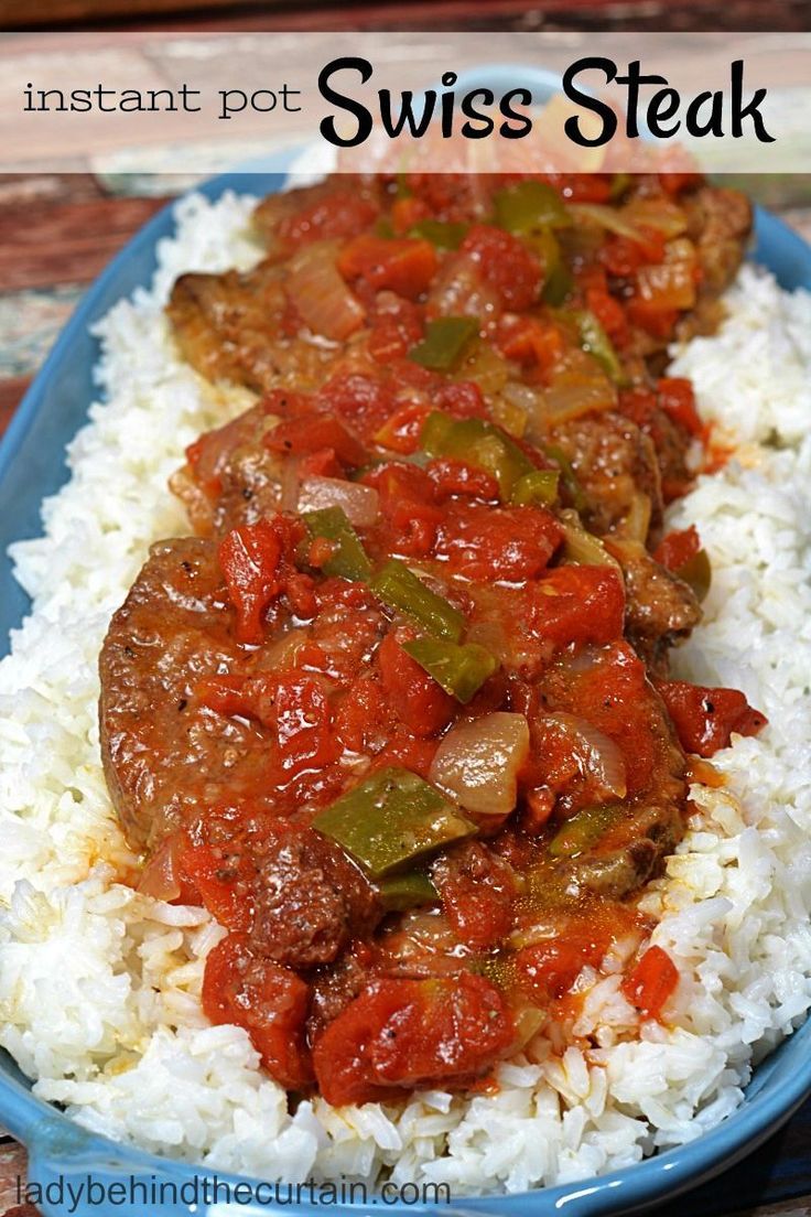 a blue plate topped with rice and meat covered in red sauce on top of a wooden table