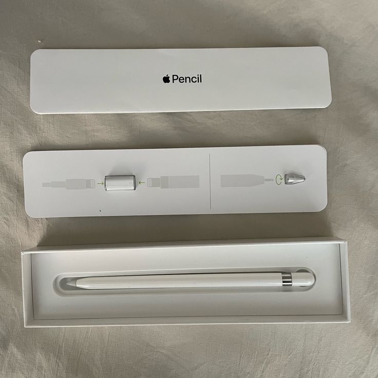 an apple pencil and its packaging on a bed sheet with the box open to reveal it's new logo