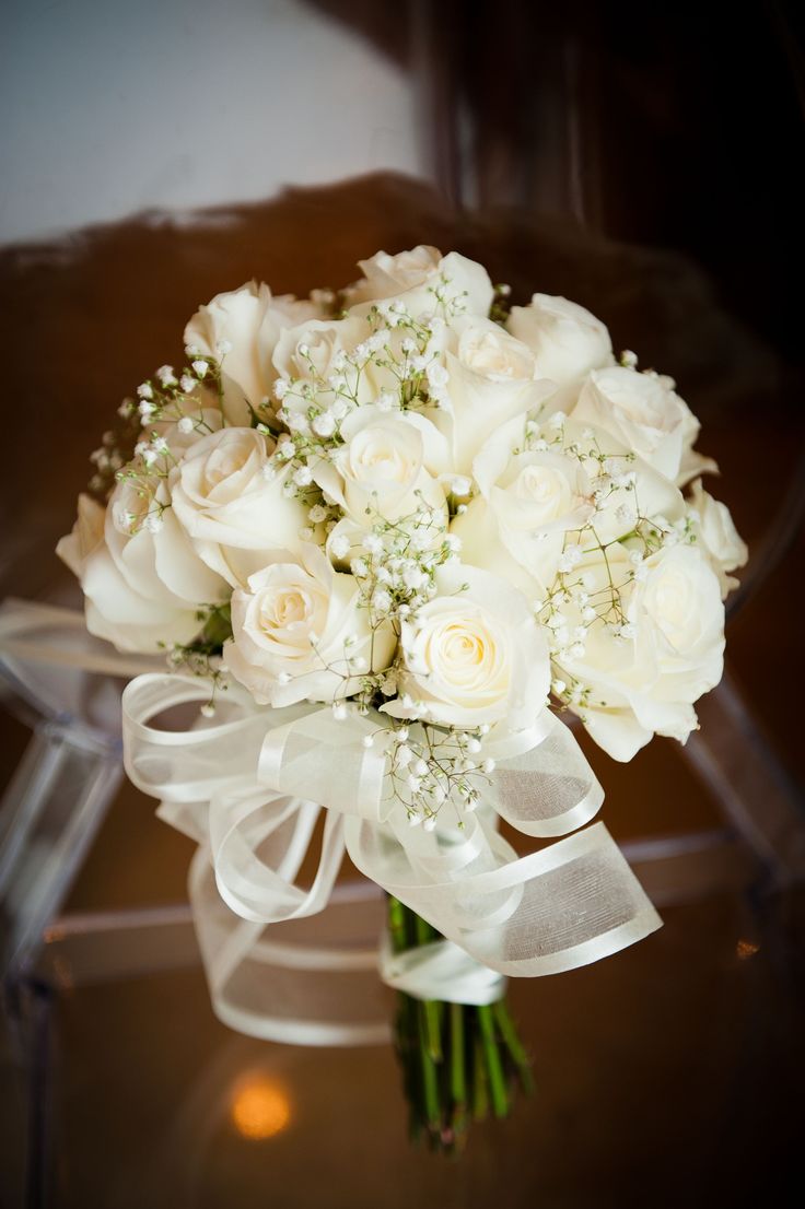 a bridal bouquet with white roses and baby's breath