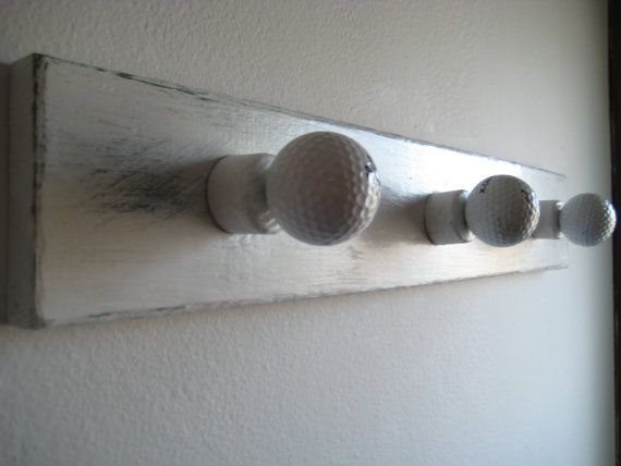 three golf balls are mounted to the wall with knobs on each one and two holes in the middle