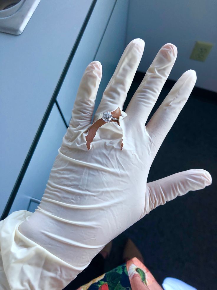 a person wearing white gloves and a ring on their hand