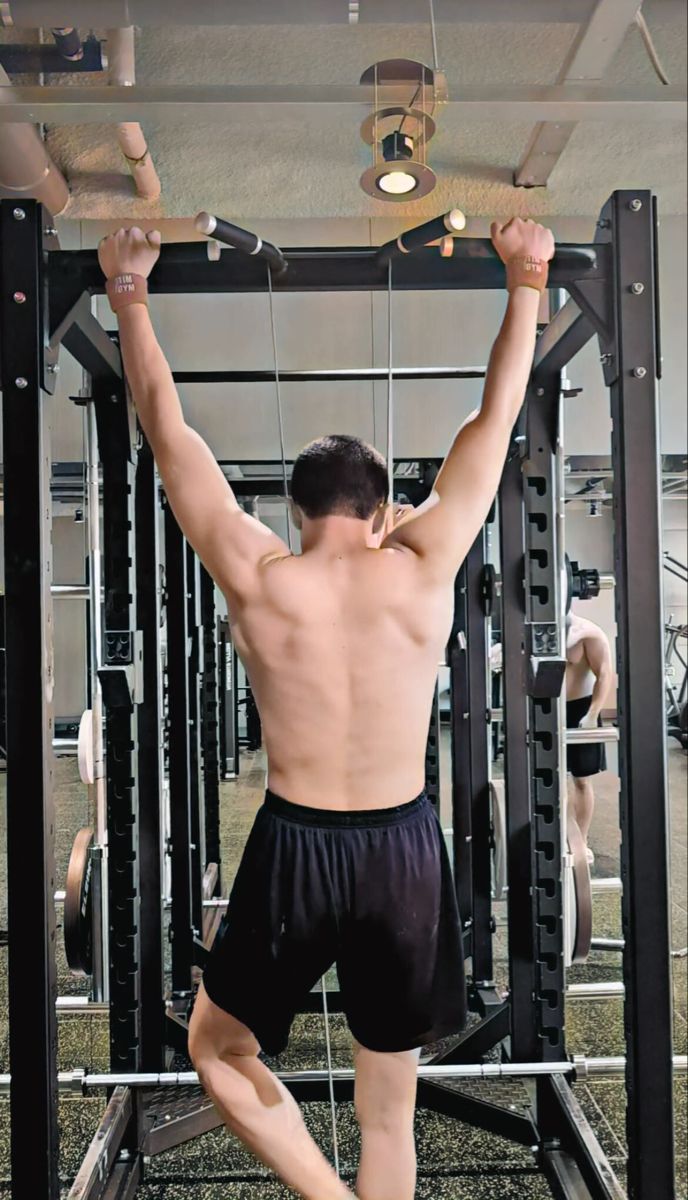 a man is doing pull ups in the gym