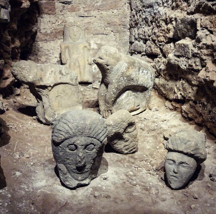 three stone heads are on display in an exhibit