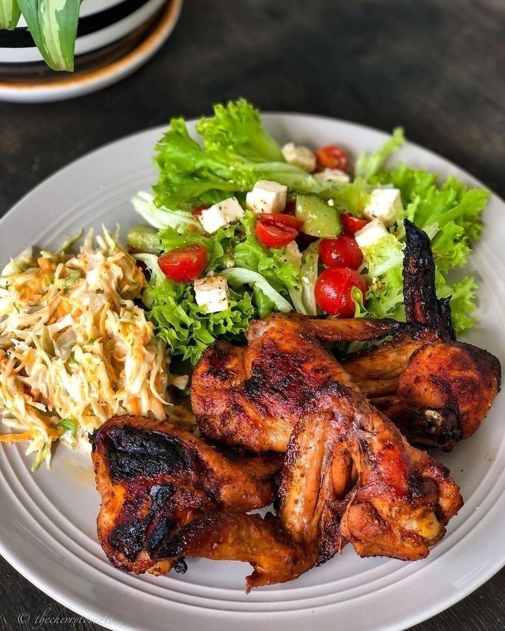 a white plate topped with chicken and salad