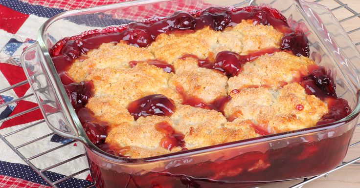 a casserole dish with cherries and crumbs in it on a table