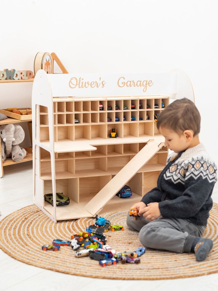 a young boy playing with toys in a room filled with wooden shelves and toy bins