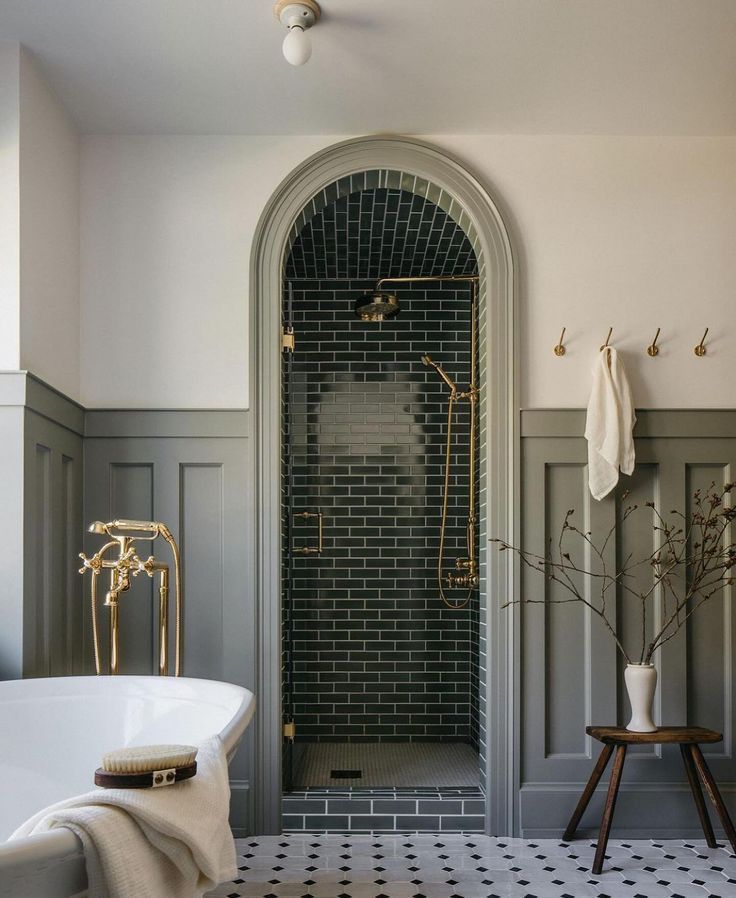 a white bath tub sitting next to a black and white tiled floor in a bathroom