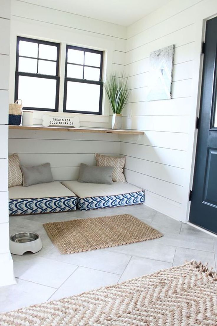 a dog is laying on the floor in front of a door and some rugs