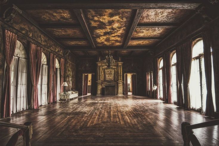 an empty room with wooden floors and large windows