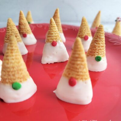 small cones with candy on them sitting on a red plate