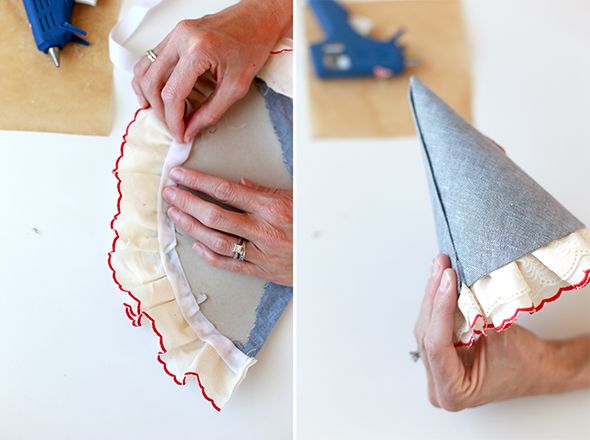 someone is making a paper cone hat out of fabric