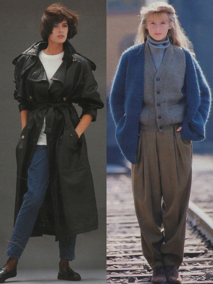 two women in coats and pants standing next to each other on the same train track