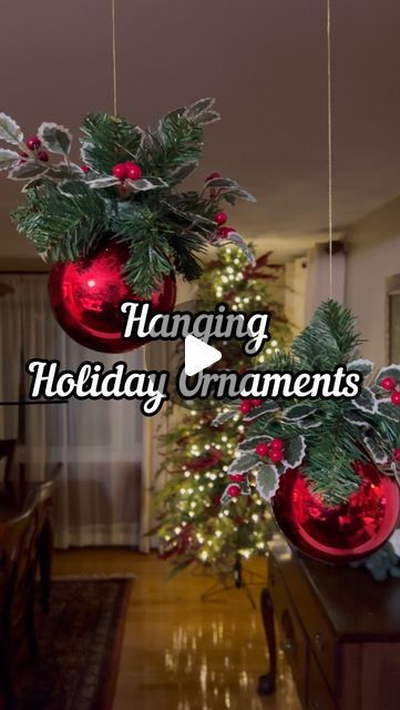 christmas decorations hanging from the ceiling in front of a living room and dining room table