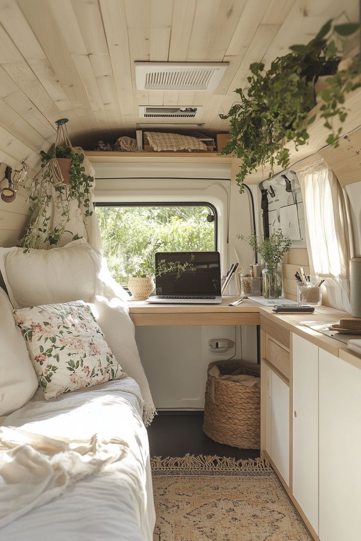 the interior of a small camper with plants growing on the windowsill and bed