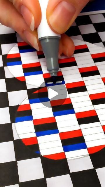 a person using a marker to draw an apple on a checkerboard surface with red, white and blue squares