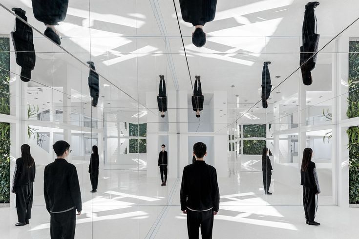 a group of people standing in a room with mirrors