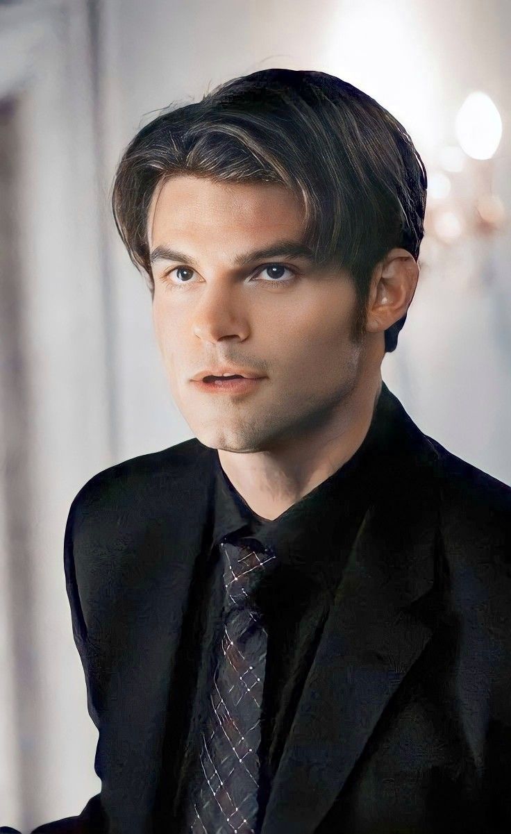 a man in a suit and tie looking at the camera with an intense look on his face