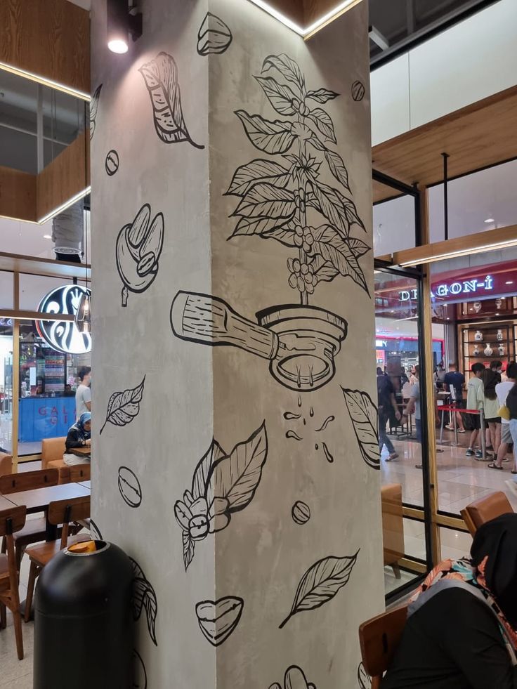 people sitting at tables in a restaurant with drawings on the wall