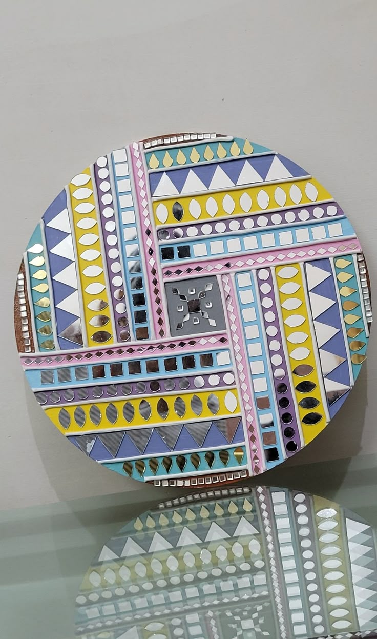 a colorful clock sitting on top of a glass table