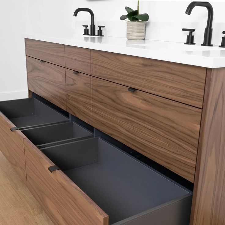 a bathroom vanity with two sinks and large drawers under the faucet is shown