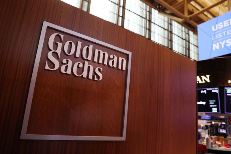 a sign that says goldman sacs in front of a wall with information on it