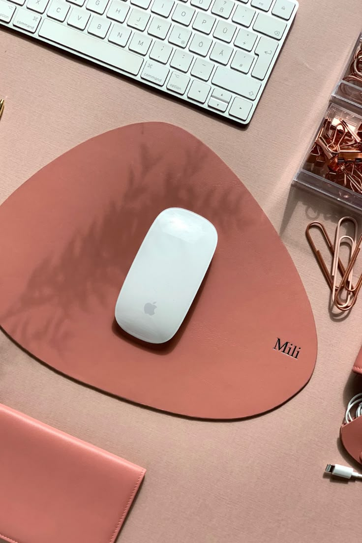 a mouse pad with a computer keyboard and other office supplies around it on a desk