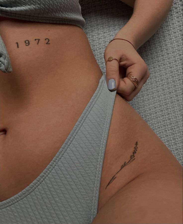 a woman is showing off her stomach with the number one on it's side