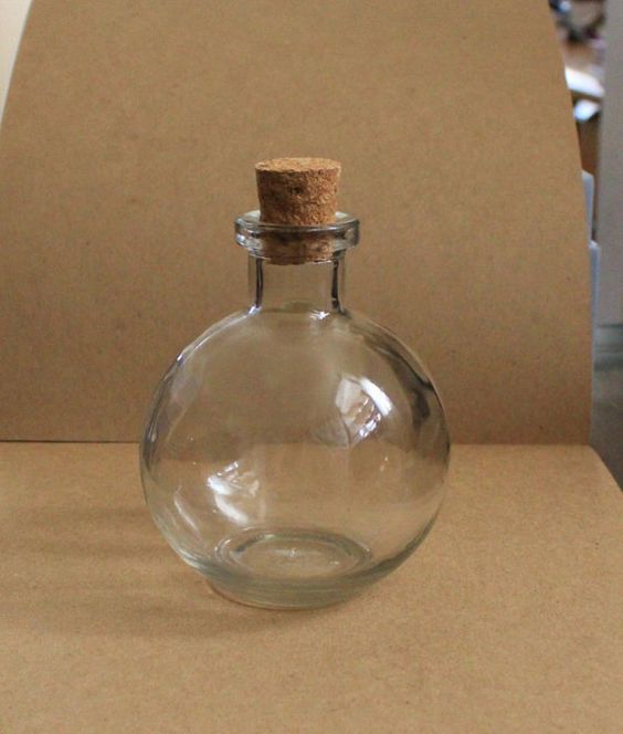 an empty glass bottle with a cork top