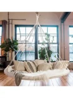 a living room filled with lots of furniture next to large windows on top of a hard wood floor