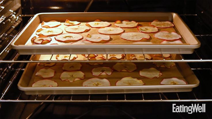 two pans filled with apples on top of an oven