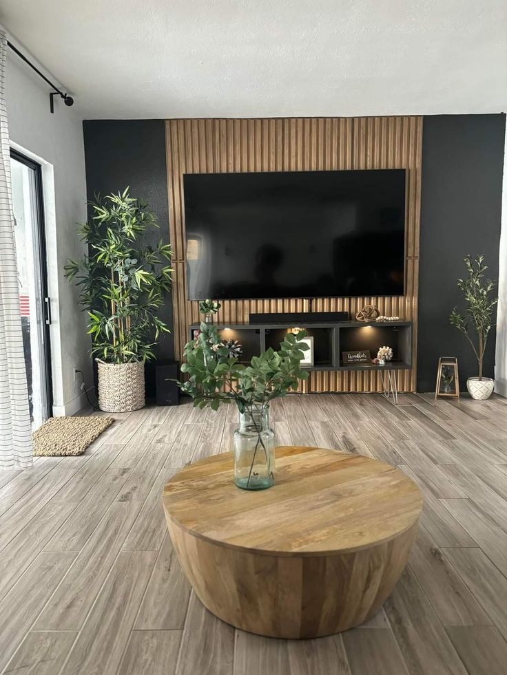 a living room filled with furniture and a flat screen tv mounted on a wall above a wooden coffee table