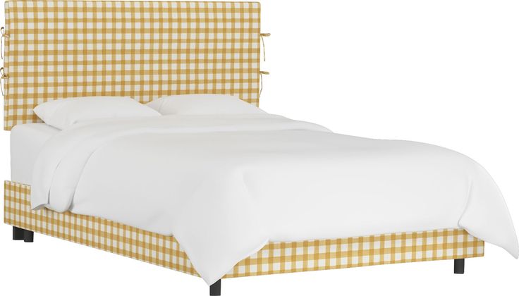 a bed with white sheets and yellow checkered headboard