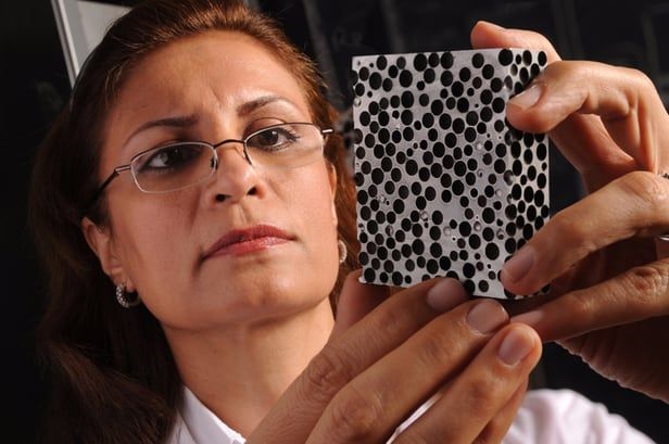 a woman holding up a card with black and white dots on it, while another person holds