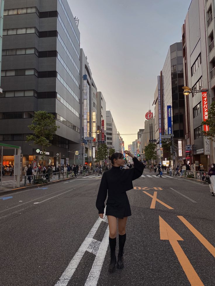 a woman walking down the middle of a street