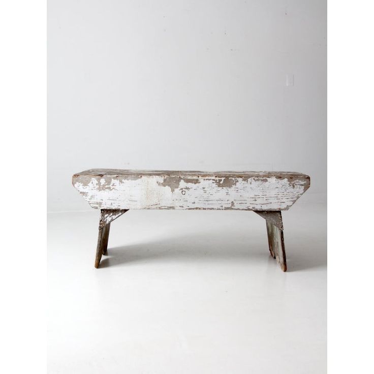 an old wooden bench sitting on top of a white floor