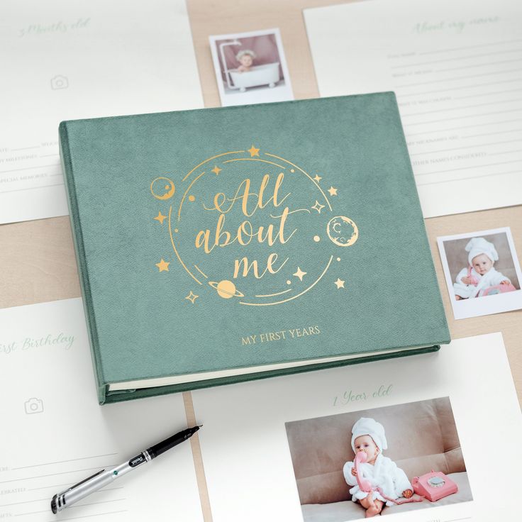 a baby's first year book with photos on it and a pen next to it