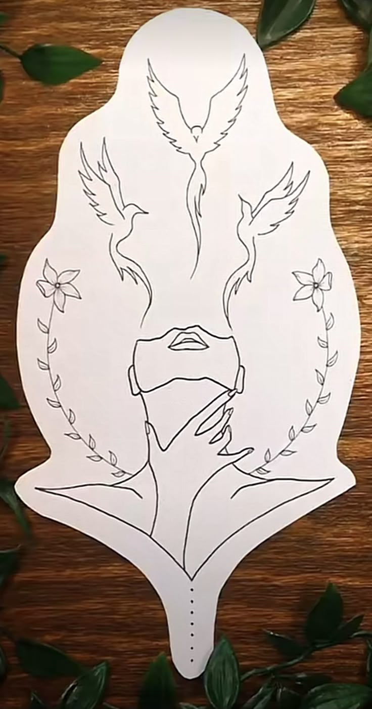 a paper cut out of a woman's face surrounded by leaves