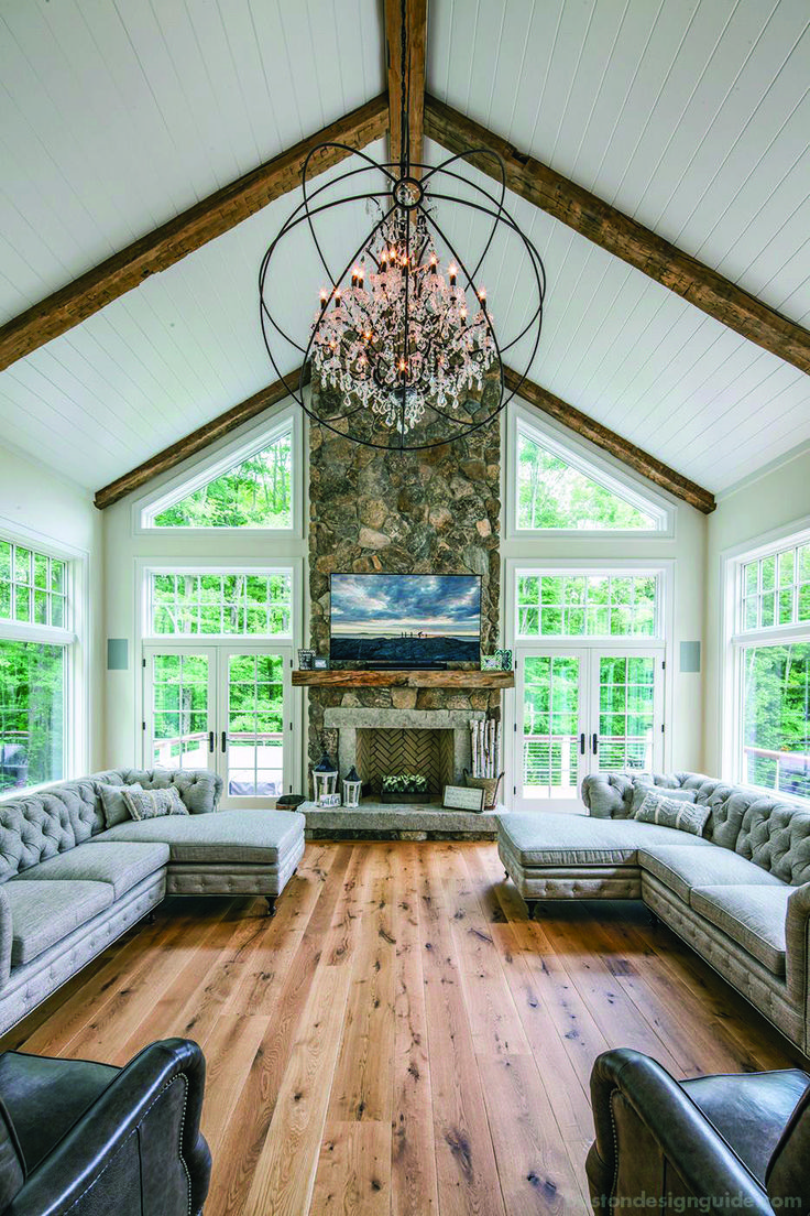 a living room filled with lots of furniture and a chandelier hanging from the ceiling