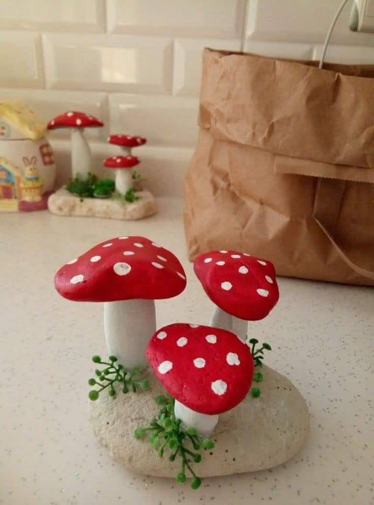 two red mushrooms sitting on top of a white counter next to a brown paper bag