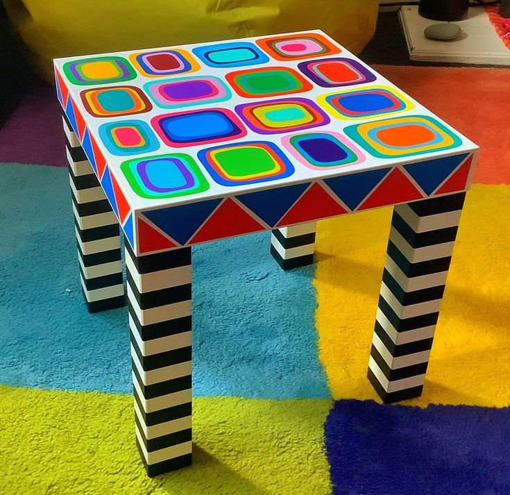 a multicolored table sitting on top of a colorful rug