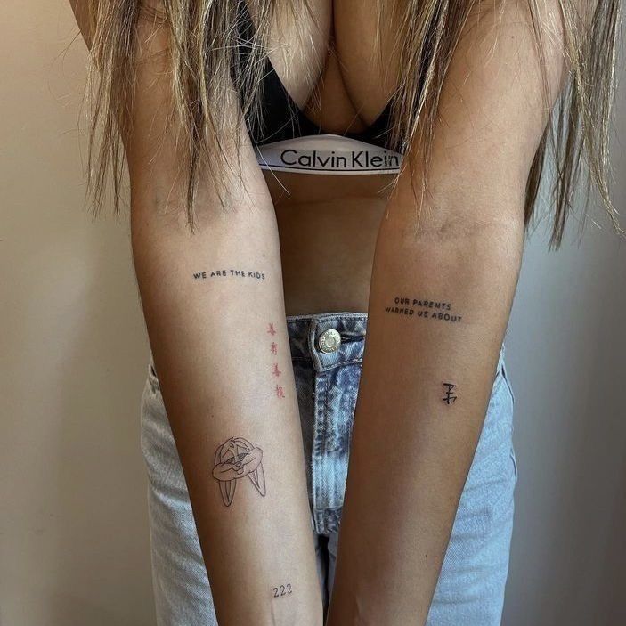 two girls with matching tattoos on their arms