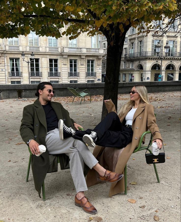 a man and woman sitting next to each other under a tree