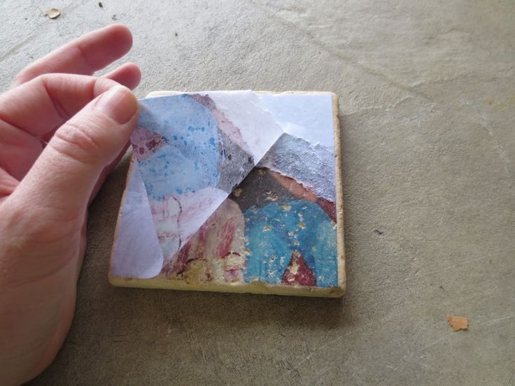 a hand is holding up a piece of paper that has been altered to look like an abstract painting