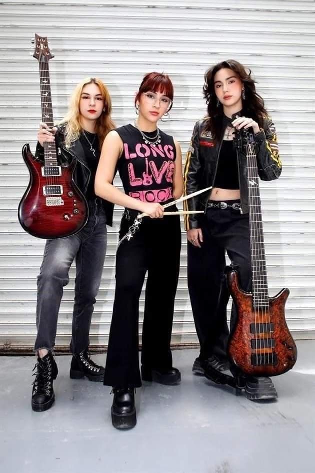 three young women standing next to each other holding guitars