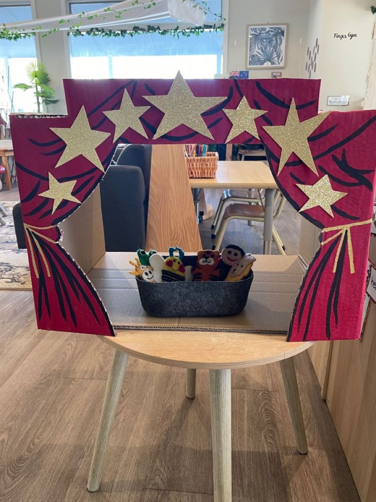 a chair with red and gold stars on it in the middle of a room filled with desks