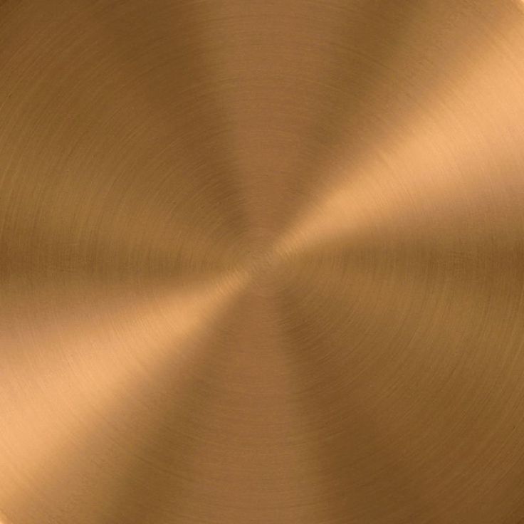 a close up view of a gold metal plate with some light brown highlights on it